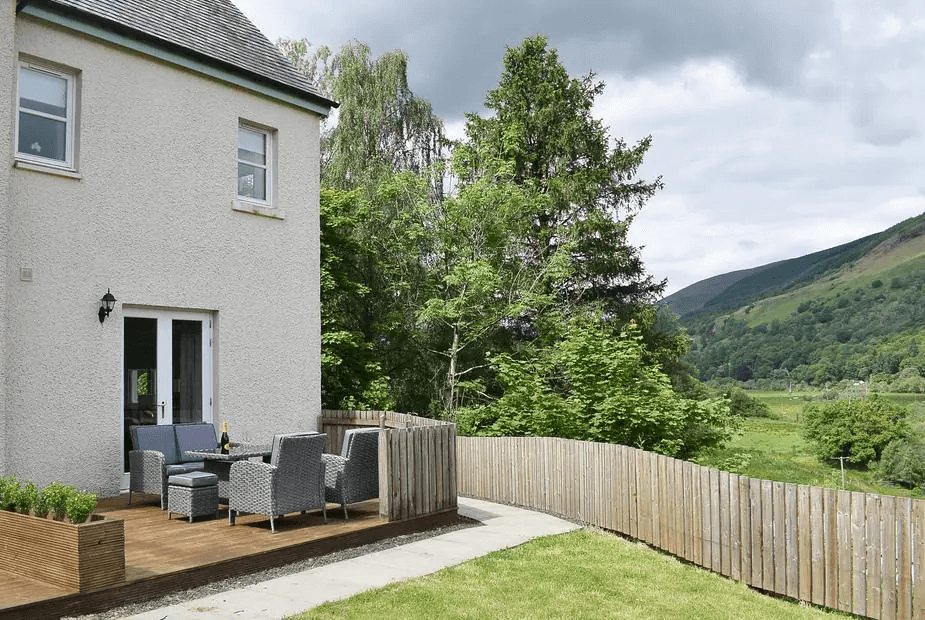 Forth View with raised wooden deck and rattan furniture overlooking wooded valley, Aberfoyle