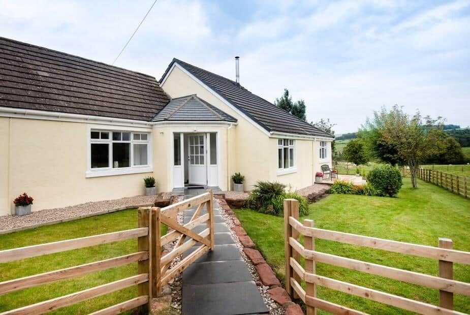Gaidrew Cottage white single-storey cottage with slate roof and garden fence, Drymen