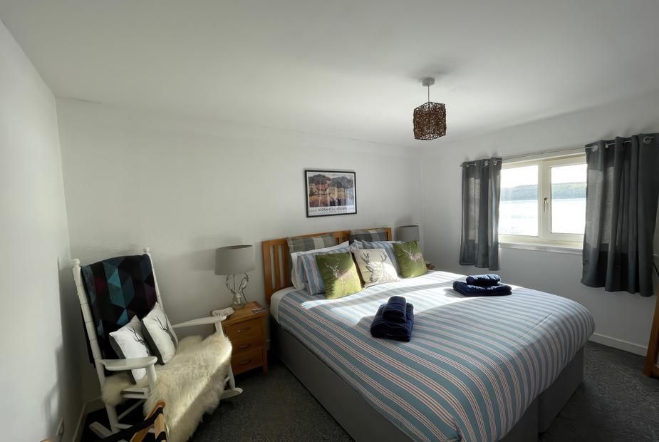 Bedroom with blue striped bedding and waterfront views at Pier View