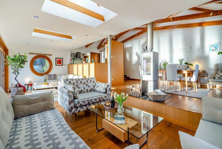Open-plan living area with high ceilings, skylights, and wood-burning stove at Shore House