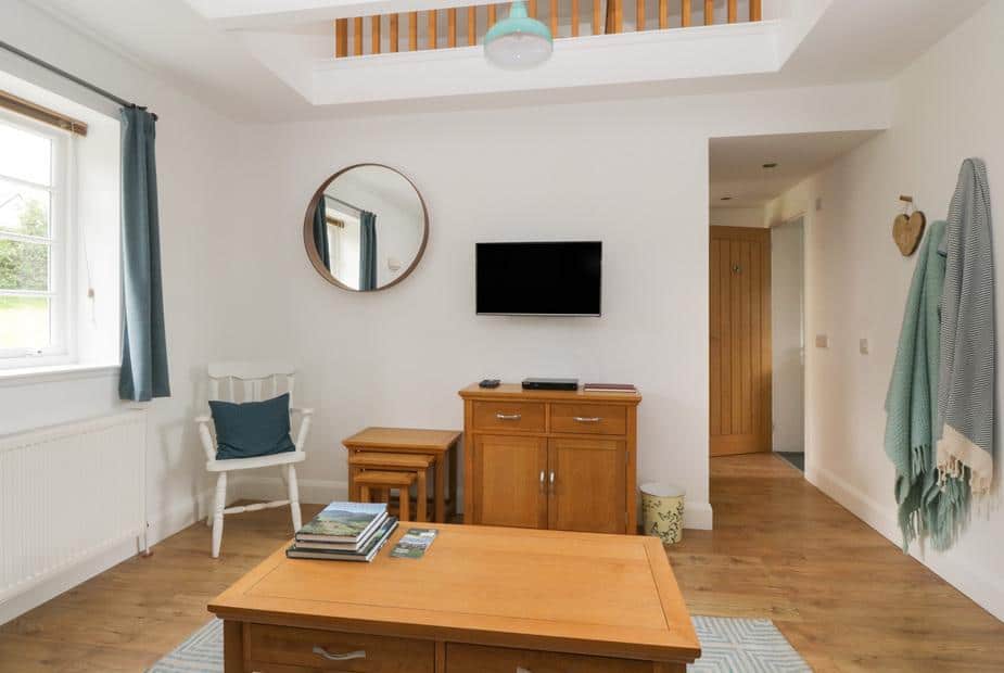 Bright living area with wooden flooring and sideboard at Ellanderroch