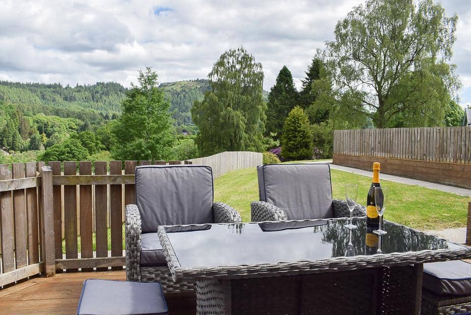 Rattan outdoor seating on the deck with scenic views of Aberfoyle hills at Forth View