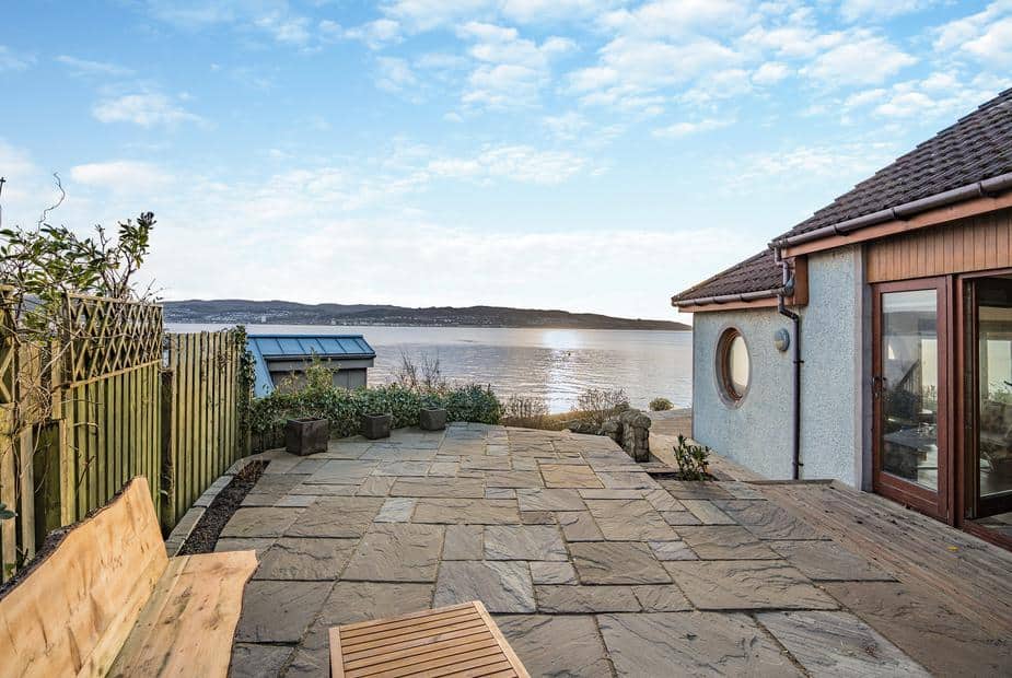 Stone terrace with wooden bench overlooking the Firth of Clyde at Shore House, Kilcreggan